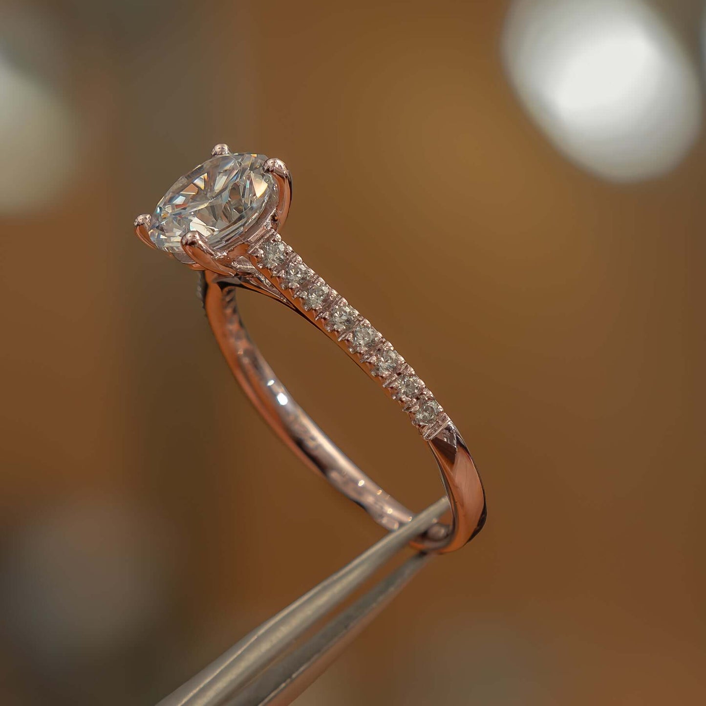 studio side image of luxury round rose gold diamond set shoulders lab grown diamond engagement ring