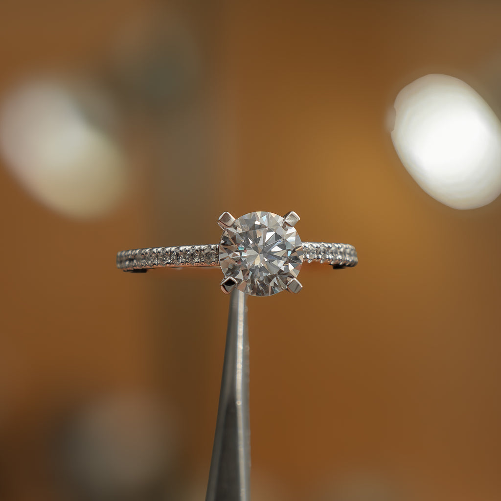 frontal view in studio of luxury round white gold diamond set shoulders lab grown diamond engagement ring